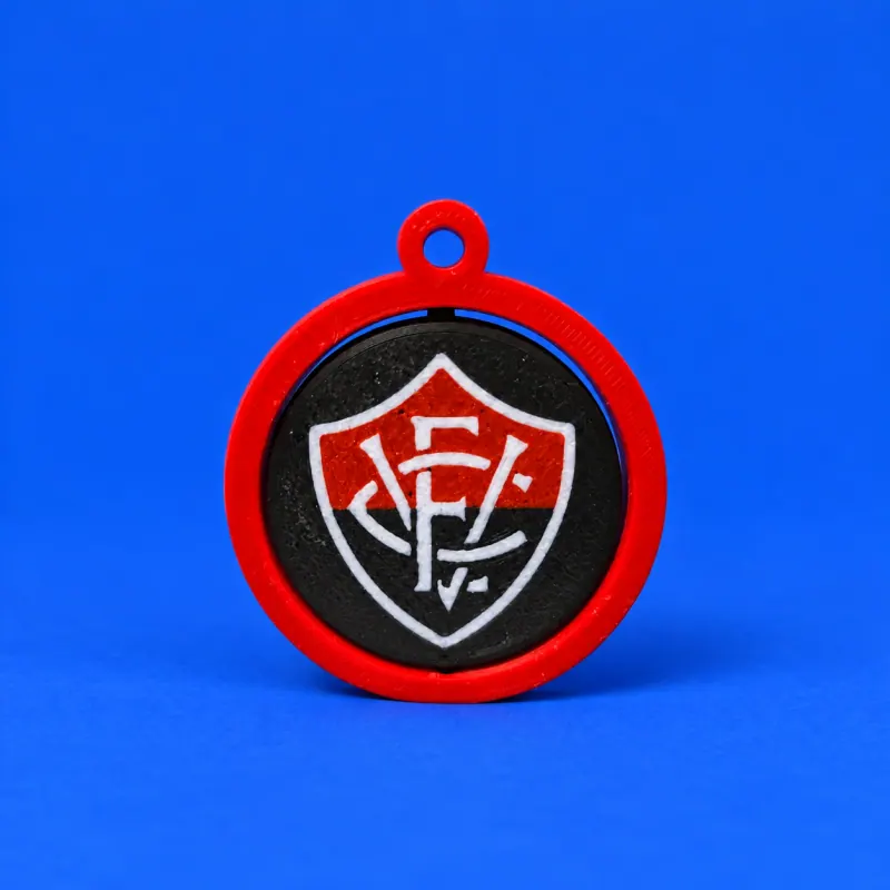 Chaveiro giratório do Vitória com aro e elo vermelhos, disco preto e escudo vermelho preto e branco com monograma ECV, textura impressa e fundo azul