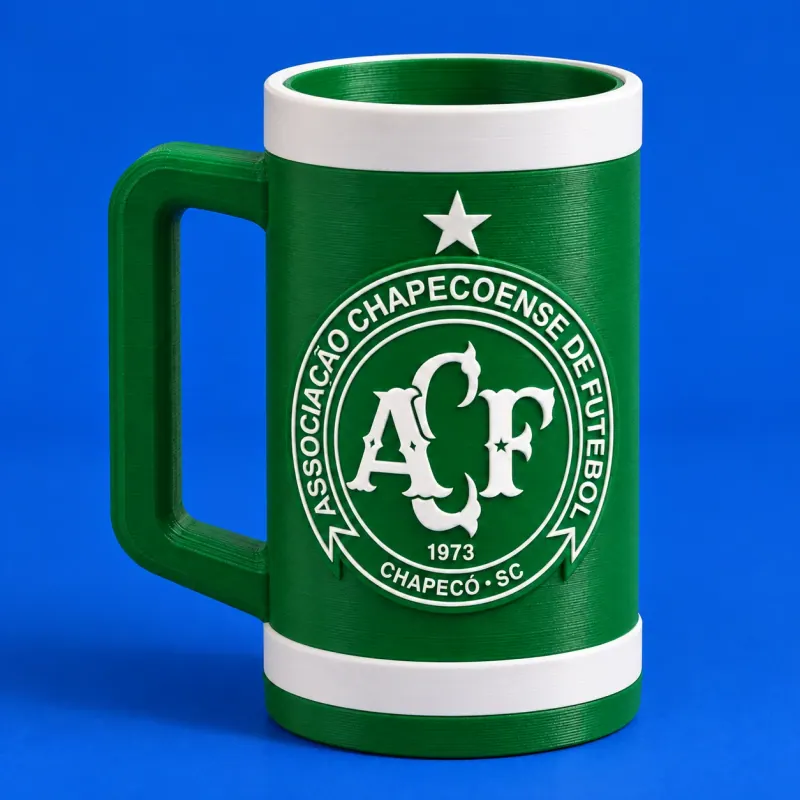 Conceito de porta-lata verde e branco da Chapecoense, com alça lateral conectada e escudo frontal em relevo, apoiado sobre fundo azul