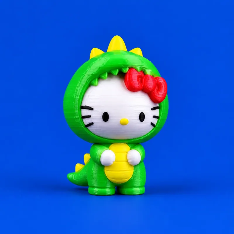 Um gatinho branco de fantasia verde de dinossauro, laço vermelho, barriga e espinhos amarelos, sobre fundo azul com camadas de impressão visíveis