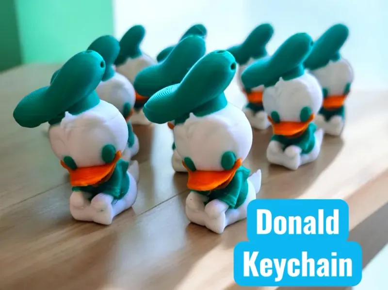 Lote de Pato Donald Bebê sentado sobre mesa, corpo branco, roupa, chapéu e olhos turquesa, bico laranja e abertura no chapéu